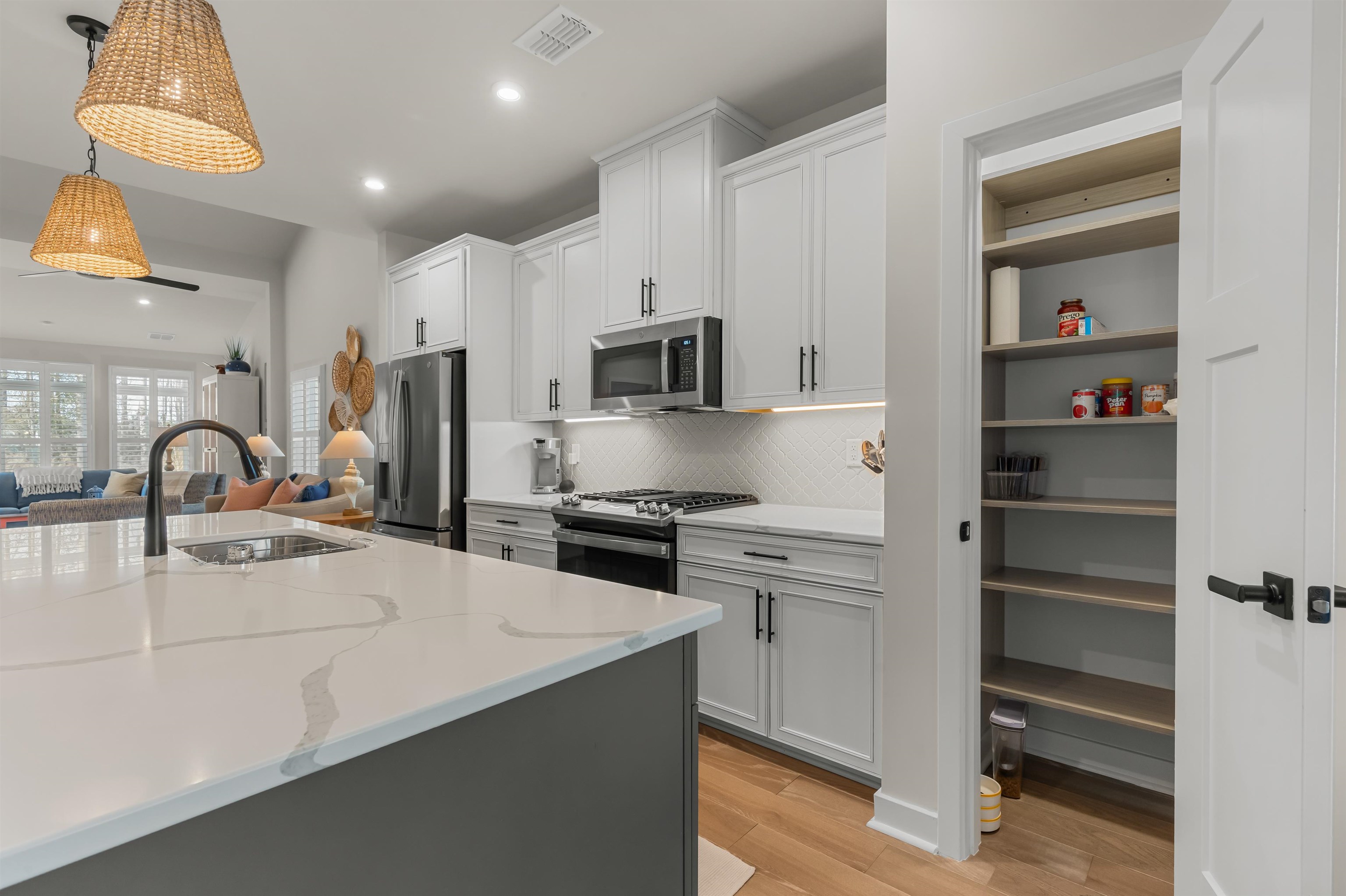 2519 Elowen Lane, Unit 9B Longs, SC 29568 - Photo 40 of 40 Kitchen with open floor plan, stainless steel appliances, light stone countertops, tasteful backsplash, and light wood-type flooring