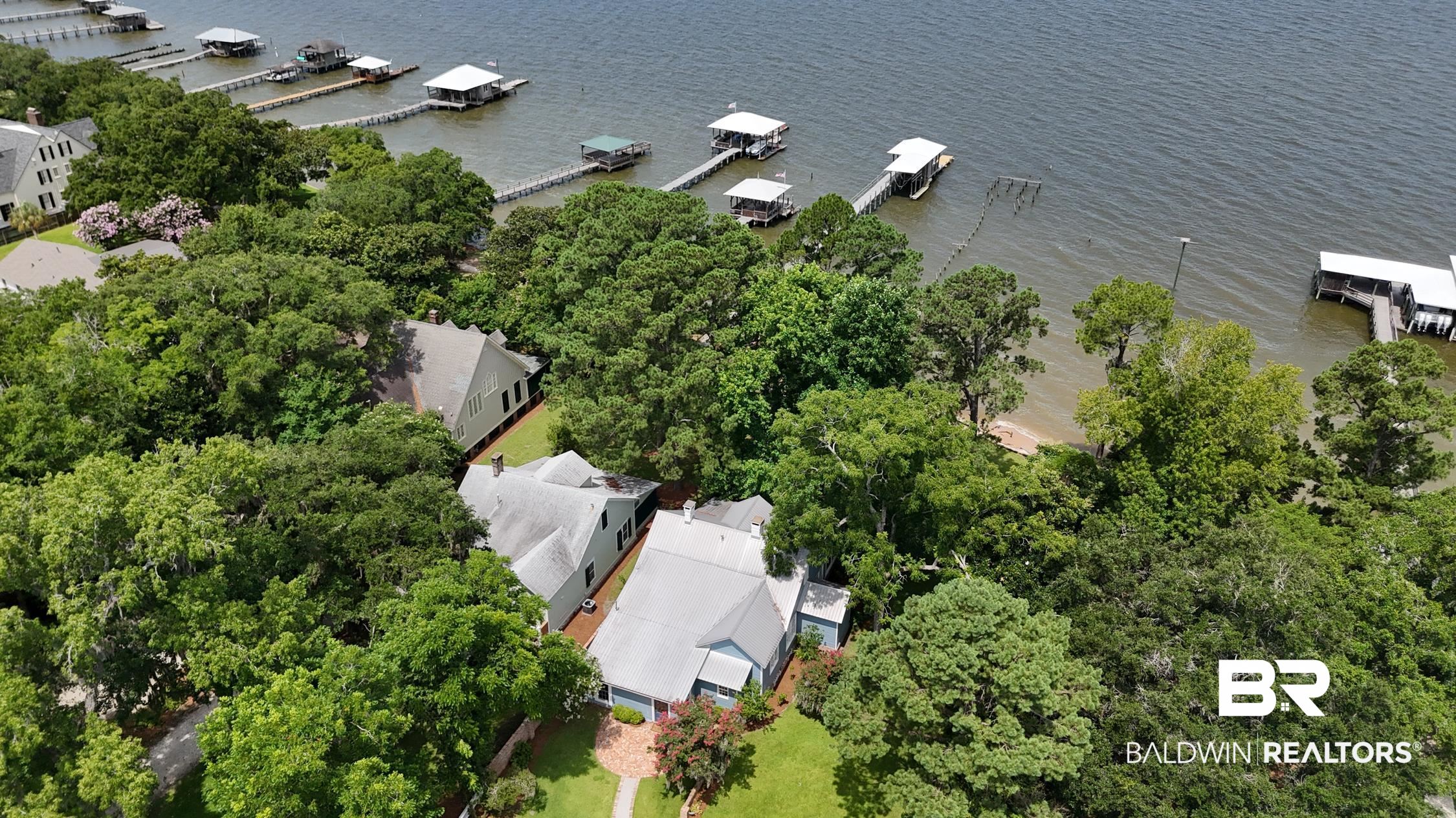 5480 Battles Road Fairhope, AL 36532 - Photo 4 of 48 Waterfront property featuring extensive mature tree coverage, a private pier with a boat lift, and a sandy shore