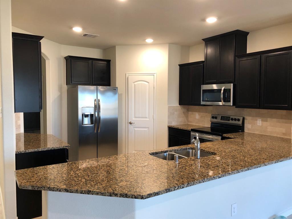 1732 Beasley Street Van Alstyne, TX 75495 - Photo 2 of 17 a kitchen with stainless steel appliances granite countertop a refrigerator a stove and a sink