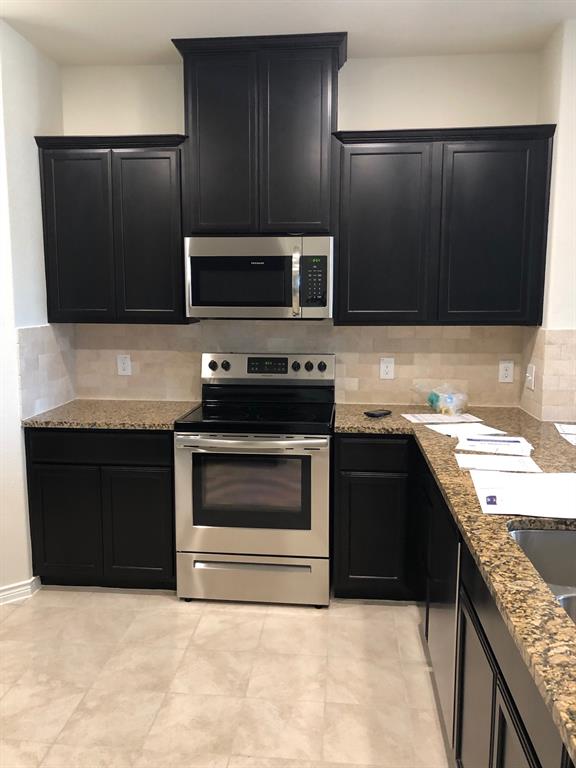 1732 Beasley Street Van Alstyne, TX 75495 - Photo 7 of 17 a kitchen with a stove and a microwave