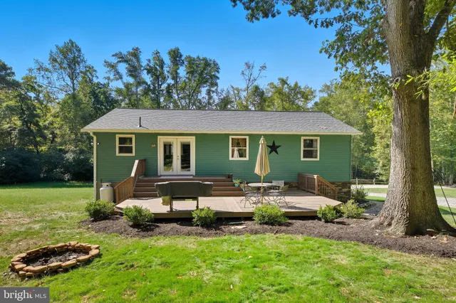 a view of a house with backyard sitting area and garden