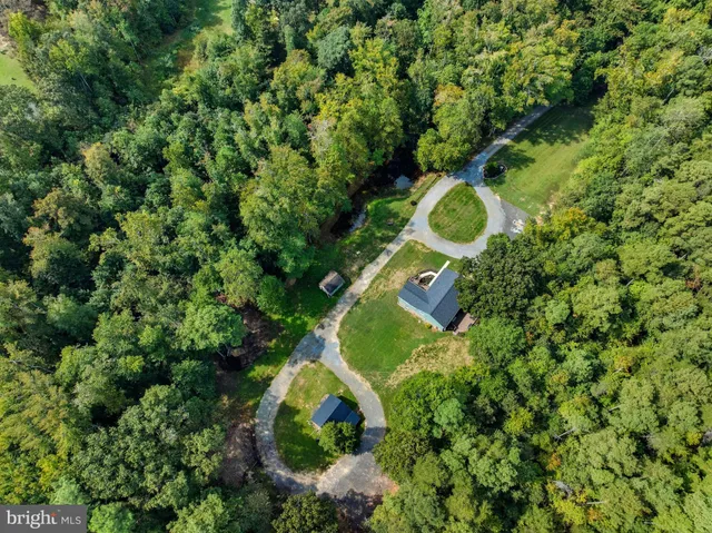 an aerial view of a house with a yard and trees