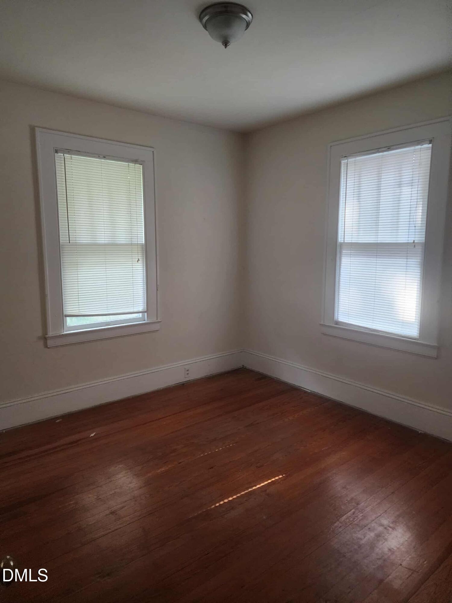 308 East Whitaker Mill Road Raleigh, NC 27608 - Photo 5 of 7 an empty room with wooden floor and windows