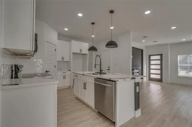 a kitchen with stainless steel appliances granite countertop a sink stove and wooden floor