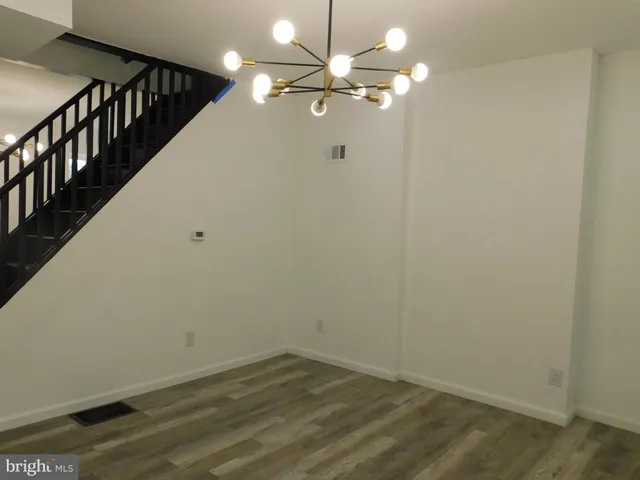 a view of a hallway with a chandelier fan and wooden floor