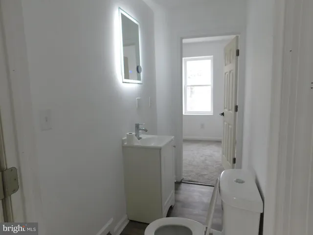 a bathroom with a toilet sink and mirror