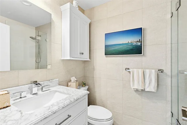 a bathroom with a granite countertop sink a mirror and toilet