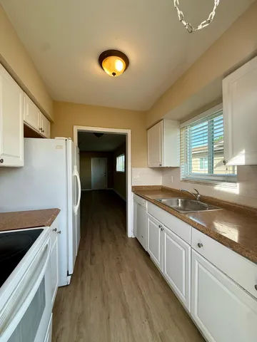 a kitchen with a sink and wooden floor