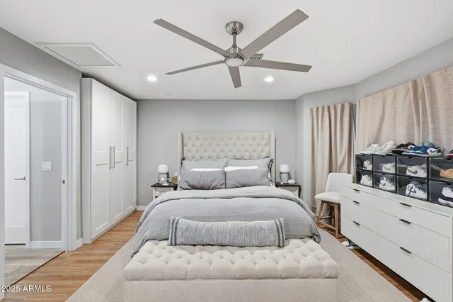 a bedroom with a large bed and ceiling fan