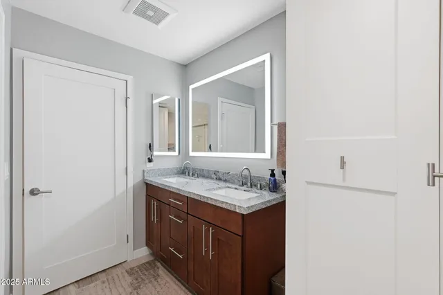 a bathroom with a granite countertop sink and a mirror