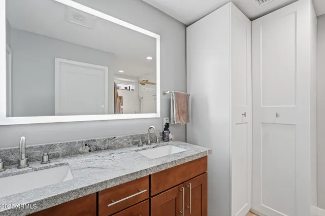 a bathroom with a granite countertop sink and a mirror