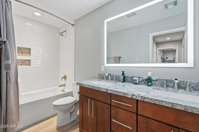 a bathroom with a granite countertop sink toilet and shower