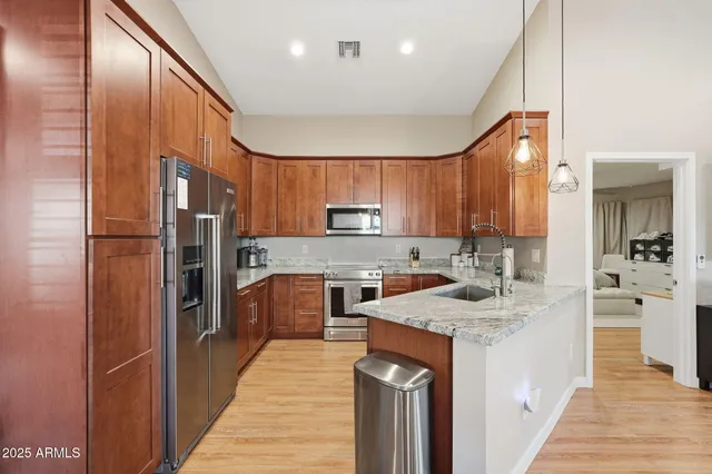 a kitchen with stainless steel appliances granite countertop a refrigerator sink and cabinets