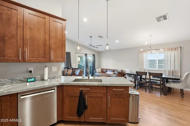 a kitchen with kitchen island granite countertop a sink cabinets and wooden floor