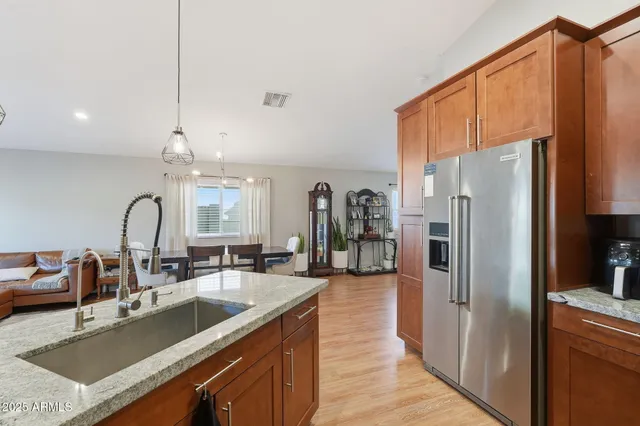 a kitchen with stainless steel appliances a sink refrigerator and cabinets