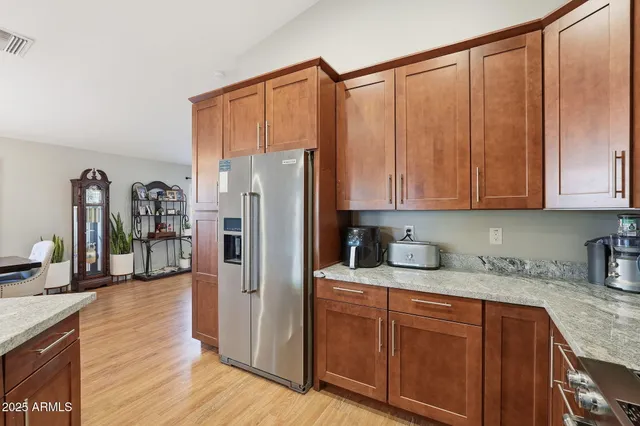 a kitchen with stainless steel appliances granite countertop a refrigerator sink and cabinets