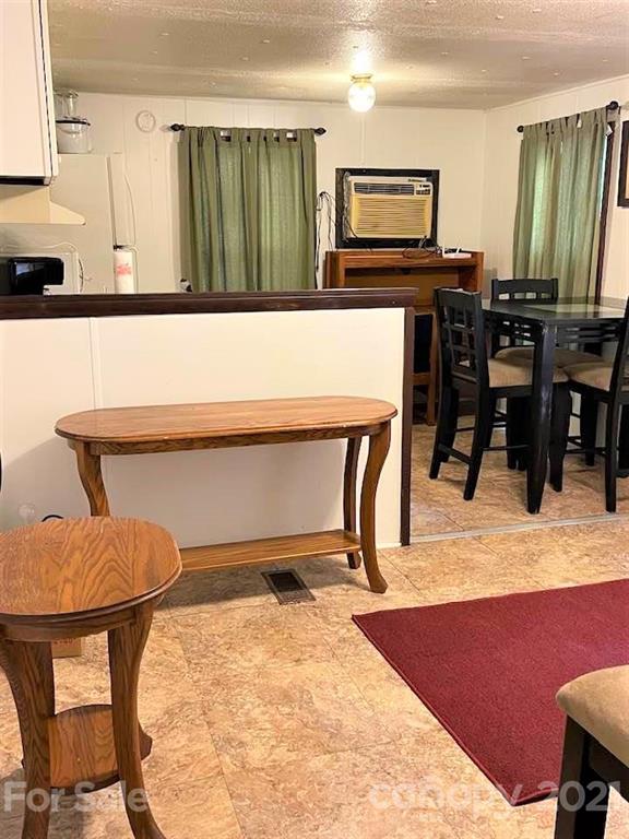 1730 Judes Gap Road, Unit 29 Mill Spring, NC 28756 - Photo 9 of 33 a living room with a table chairs and a refrigerator