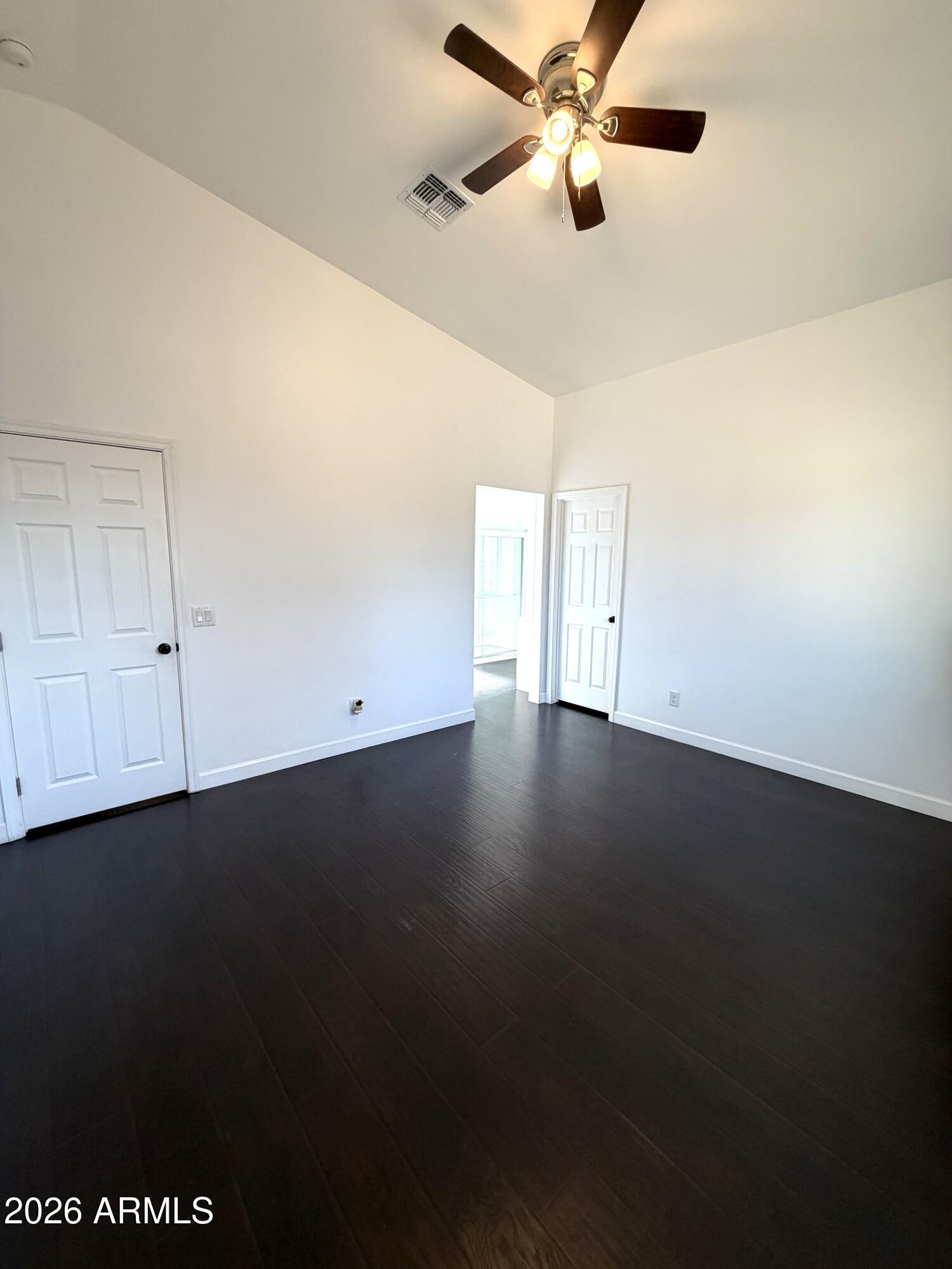 1924 West Lawrence Road Phoenix, AZ 85021 - Photo 11 of 17 a view of an empty room with wooden floor and a ceiling fan