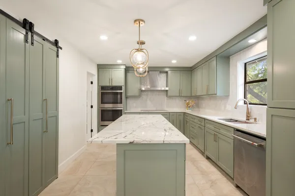 a kitchen with a sink stainless steel appliances and cabinets