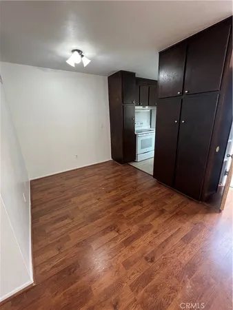 a kitchen with a refrigerator and wooden floor