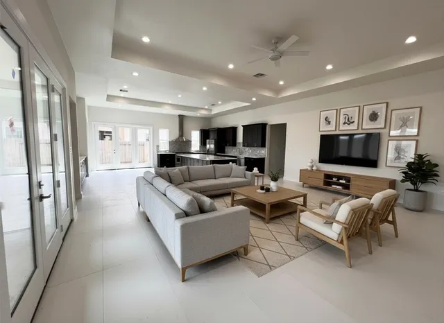 a living room with furniture kitchen view and a large window