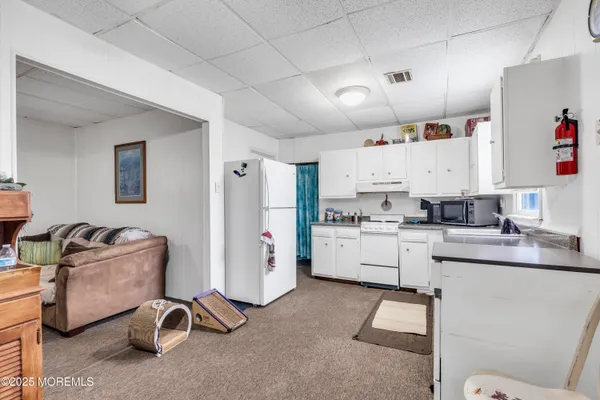 a kitchen with granite countertop a white refrigerator sink and white cabinets