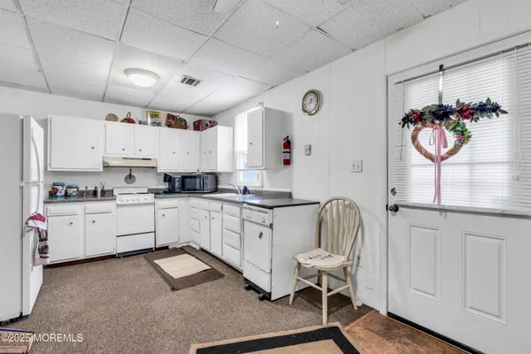 a kitchen with cabinets appliances a sink and a window