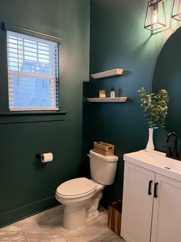 a bathroom with a toilet a sink and a window