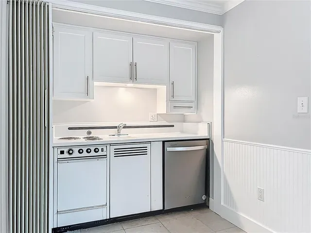 a kitchen with white cabinets and white appliances