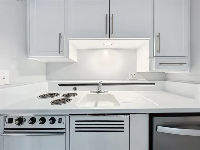 a kitchen with a stove and white cabinets
