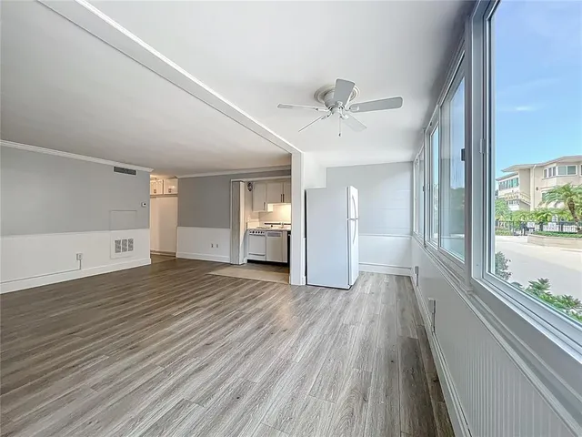 a view of empty room with wooden floor and window