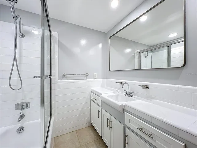 a bathroom with a double vanity sink a mirror and a bathtub