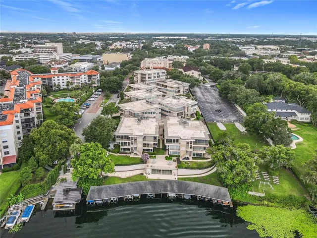 an aerial view of residential building with outdoor space and lake view in back