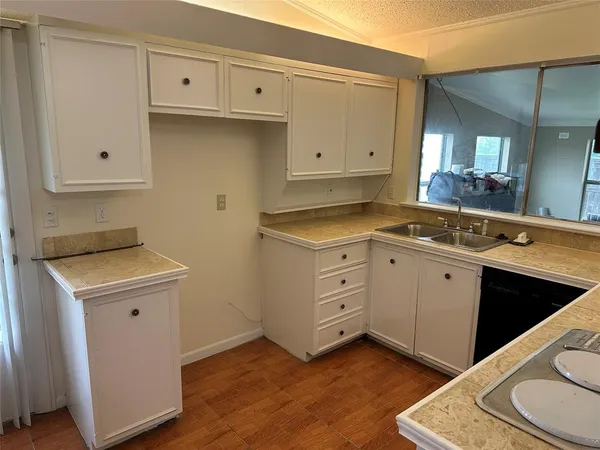 a view of a kitchen with sink and cabinets
