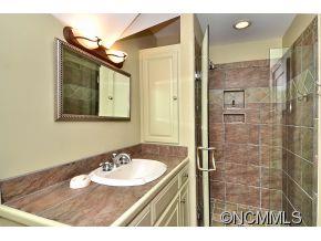 1380 Pkwy N Road Mill Spring, NC 28756 - Photo 13 of 24 a bathroom with a sink a mirror and a shower