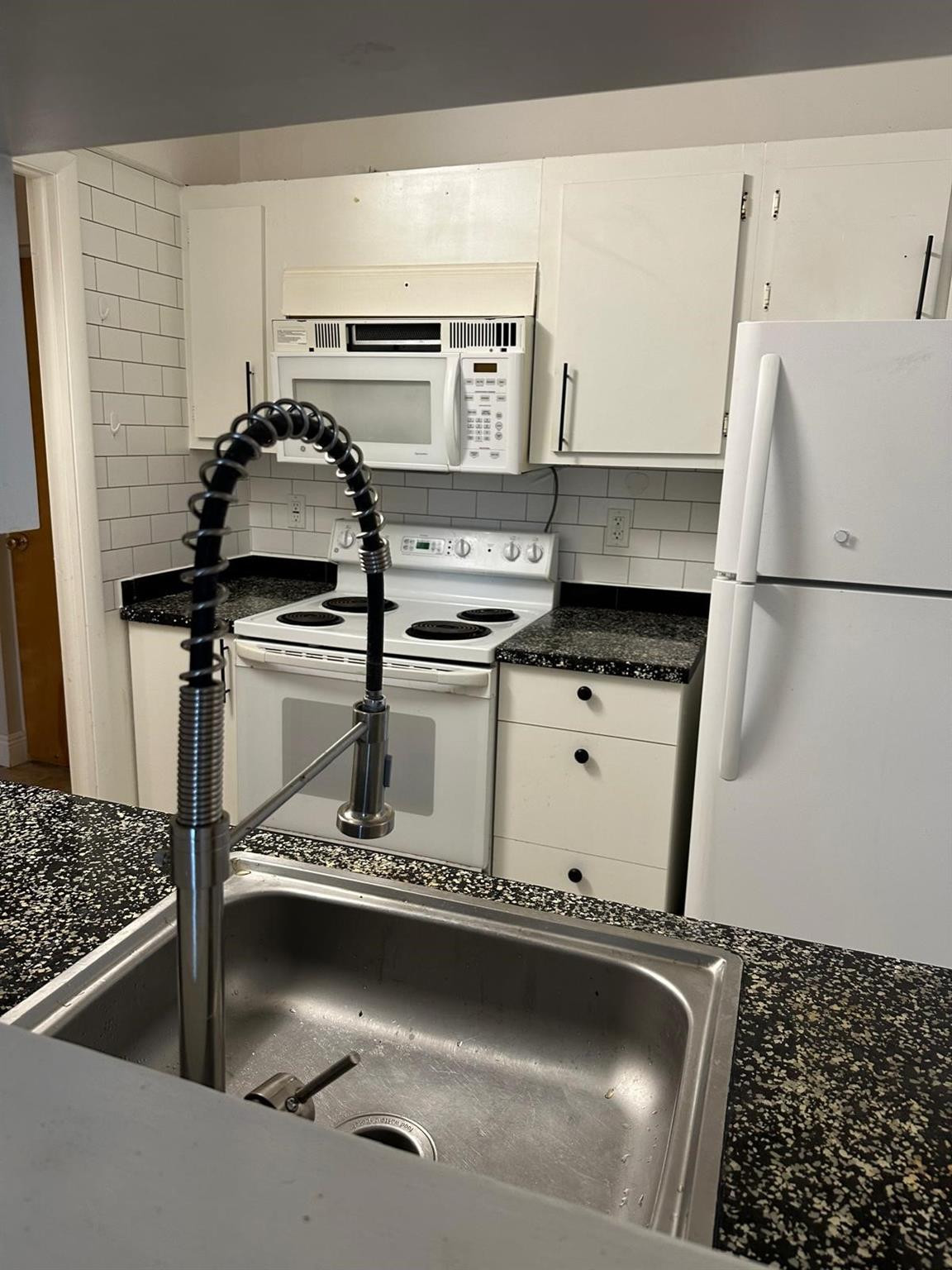 a close view of kitchen sink appliances and cabinets