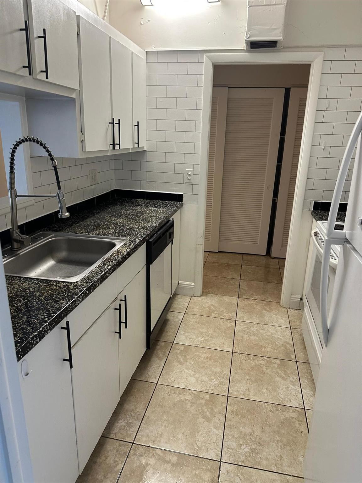 400 North Riverside Drive, Unit 102 Pompano Beach, FL 33062 - Photo 2 of 20 a kitchen with granite countertop a sink a stove and a granite counter top
