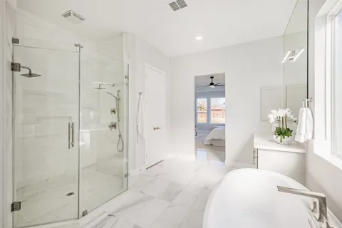 a bathroom with a double vanity sink a large mirror and a bathtub
