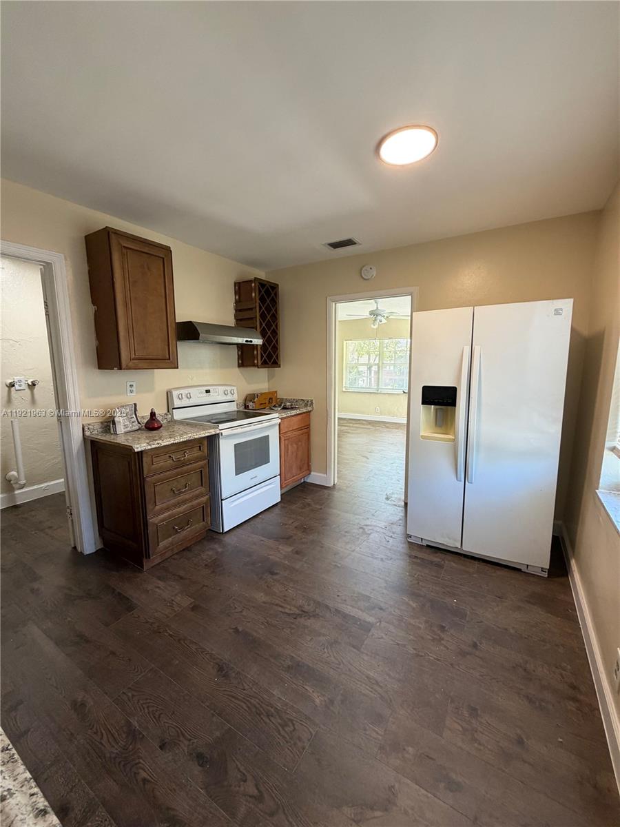 1320 Southwest 11th Avenue, Unit A Deerfield Beach, FL 33441 - Photo 2 of 9 a kitchen with stainless steel appliances granite countertop a stove a sink and a refrigerator