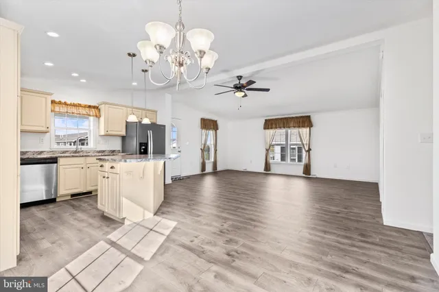 a view of kitchen with stove and white cabinets