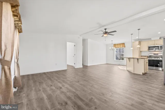 a view of a kitchen with wooden floor and a ceiling fan
