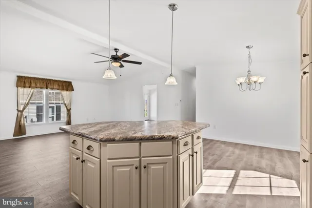 a kitchen with a table a chandelier and refrigerator