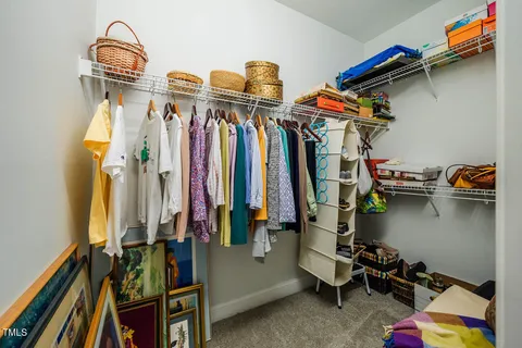 a view of walk in closet with clothes and shoes
