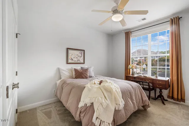a bedroom with a large bed and a chandelier