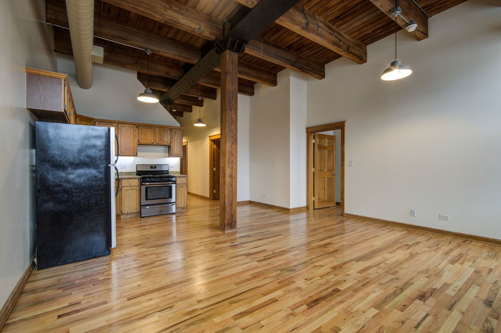 216 North May Street, Unit 303 Chicago, IL 60607 - Photo 5 of 19 a view of an empty room with kitchen view and a window
