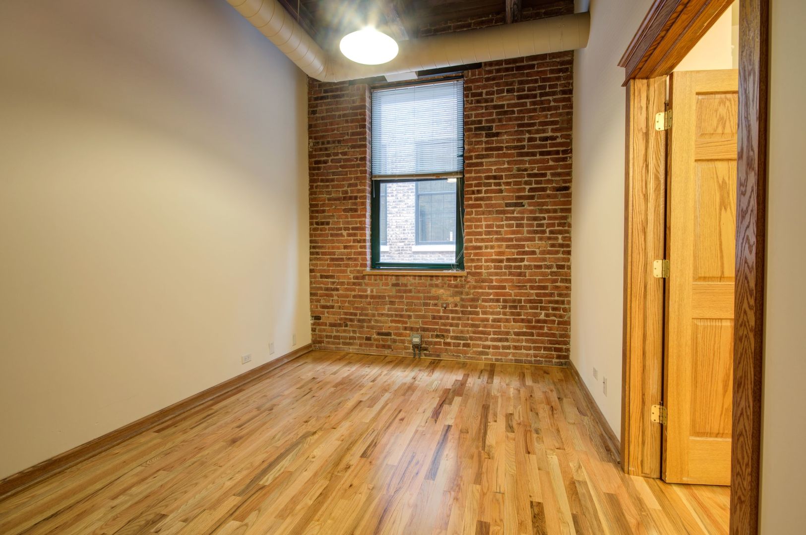 216 North May Street, Unit 303 Chicago, IL 60607 - Photo 7 of 19 a view of a room with wooden floor and a window