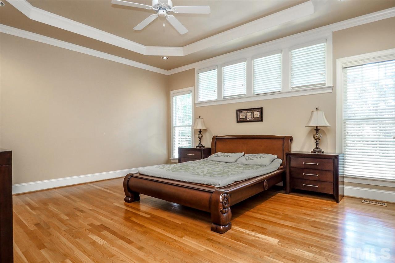 7017 Potomac Court Raleigh, NC 27613 - Photo 11 of 25 a bedroom with a bed and wooden floor