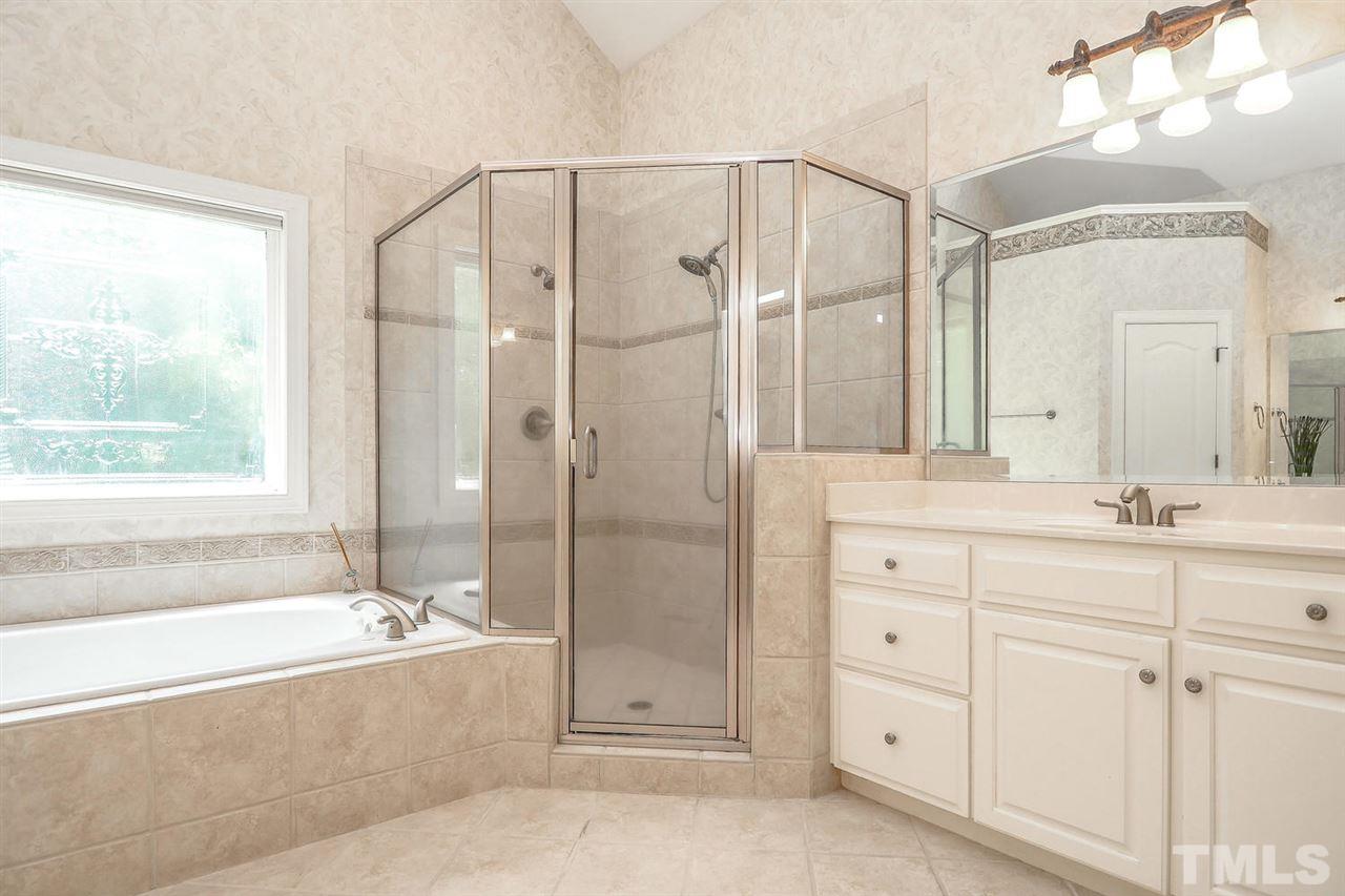 7017 Potomac Court Raleigh, NC 27613 - Photo 13 of 25 a bathroom with a double vanity sink mirror and a bathtub