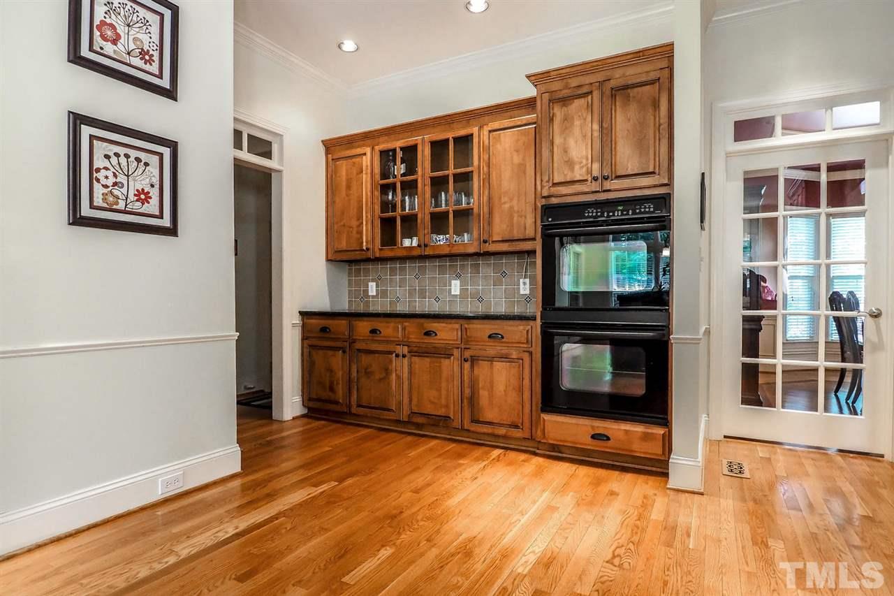 7017 Potomac Court Raleigh, NC 27613 - Photo 7 of 25 a view of a kitchen with an empty room and wooden floor