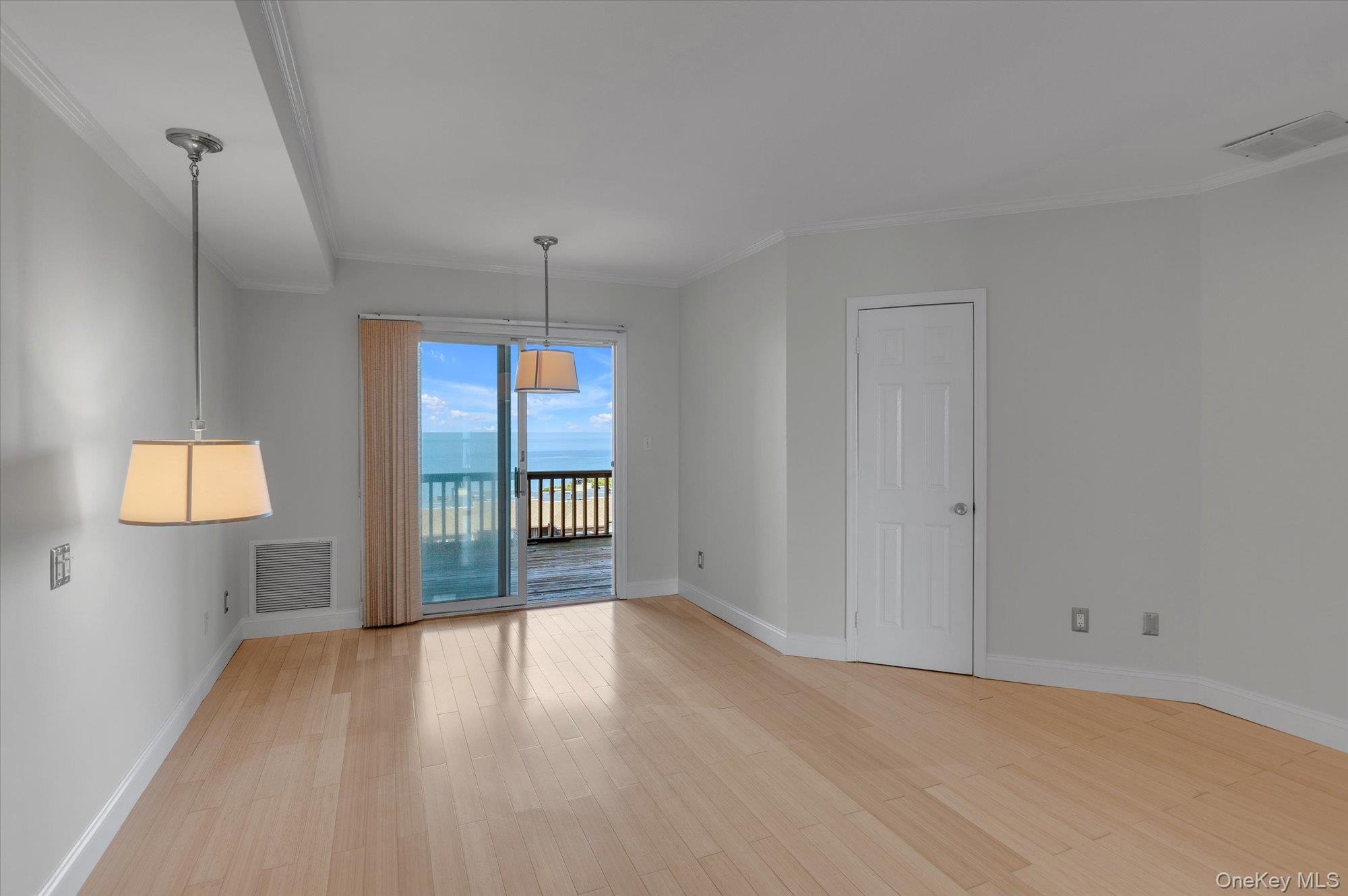 209 Fox Hill Drive Baiting Hollow, NY 11933 - Photo 12 of 28 Unfurnished room with light wood-style flooring, ornamental molding, and a water view
